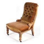 An Edwardian button back nursing chair, with bow fronted seat and turned front legs,