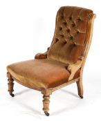 An Edwardian button back nursing chair, with bow fronted seat and turned front legs,
