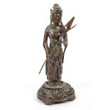 A South East Asian bronze figure of a Hindu deity holding a flower spray,