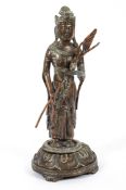 A South East Asian bronze figure of a Hindu deity holding a flower spray,