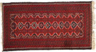 An Iranian wool rug, 20th century, red ground woven with bands of geometric ornament,