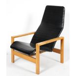 A 1970's vintage lounge chair, with ribbed black vinyl upholstery, on beech frame,