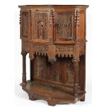 A Victorian carved oak Gothic Revival cabinet on stand, on canted D-section,
