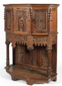 A Victorian carved oak Gothic Revival cabinet on stand, on canted D-section,