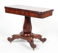 A William IV mahogany fold over top tea table on baluster column stem and four scroll legs