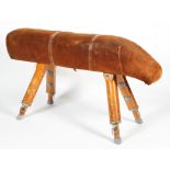 A large vintage pommel horse, bearing label for Olympic Gymnasium covered in tan suede,