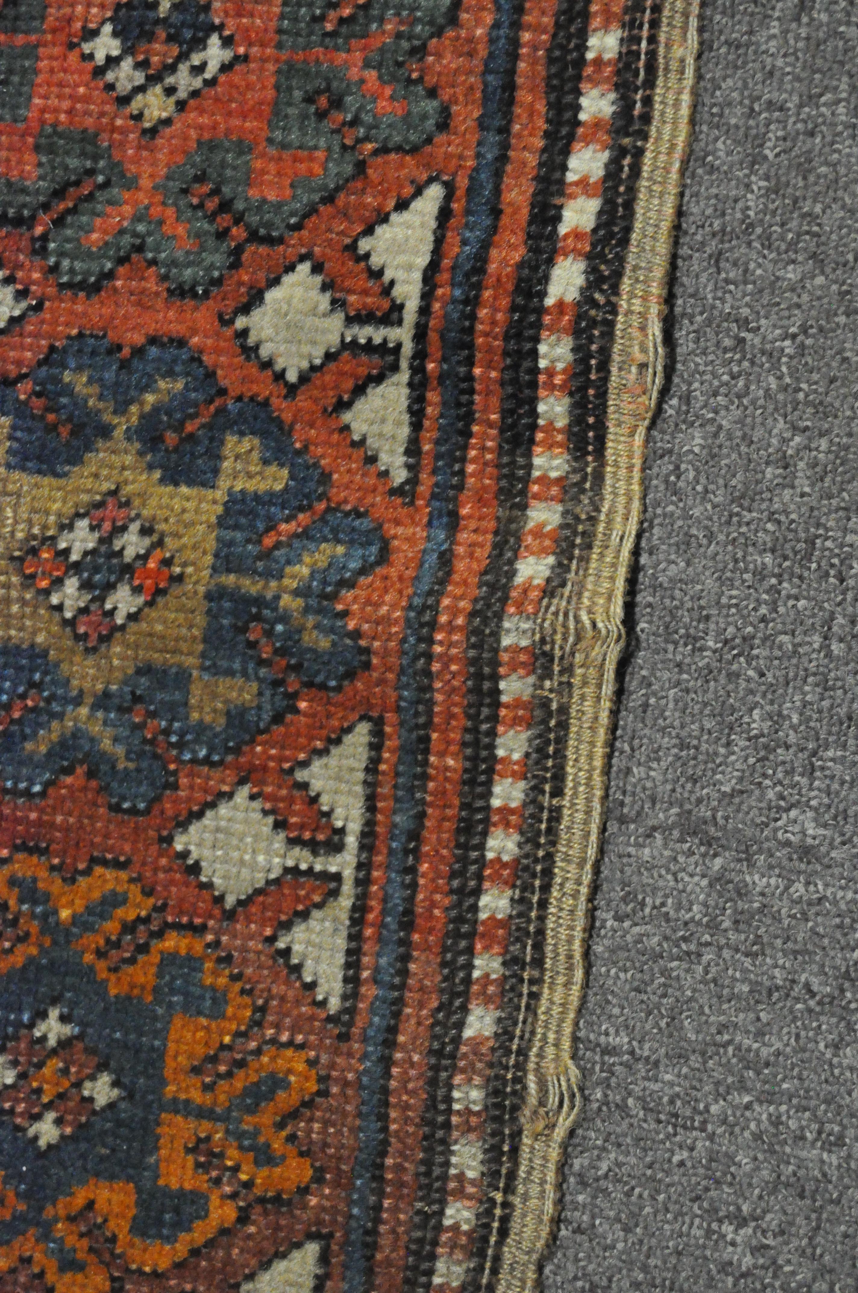 A 20th century Kazak style wool rug, woven with geometric lozenges on a blue ground with red border, - Image 6 of 13