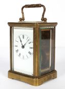 A French brass carriage clock, with white enamelled dial and black Roman numerals,
