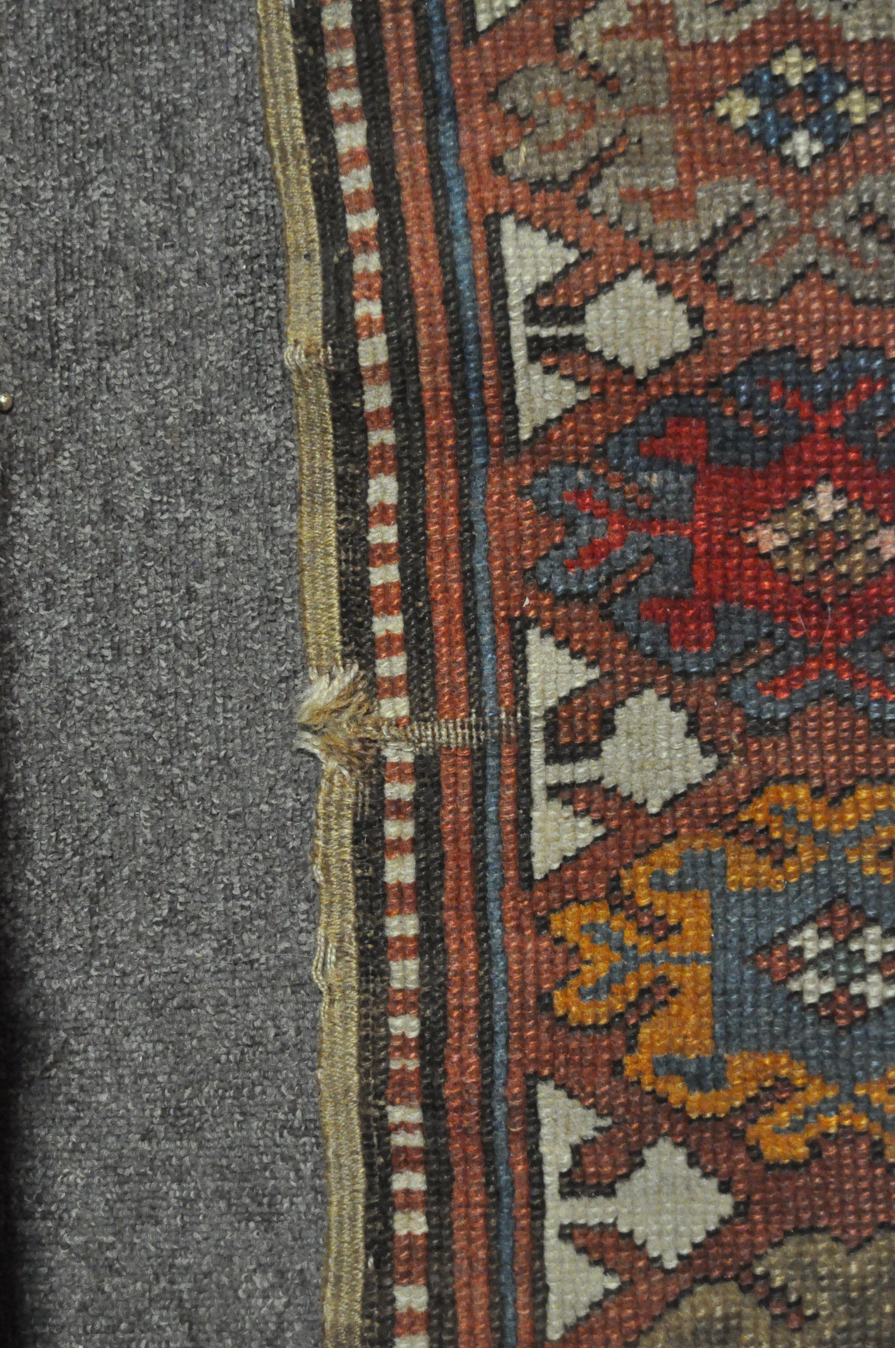 A 20th century Kazak style wool rug, woven with geometric lozenges on a blue ground with red border, - Image 9 of 13