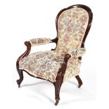 A Victorian spoon back armchair, with a walnut frame and tapestry upholstery,