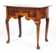 A George II oak low boy, with canted cross banded top above three drawers with brass swing handles,