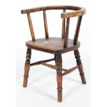A child's oak chair, with horseshoe shaped back rail and spindle back on turned baluster legs,