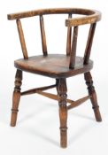 A child's oak chair, with horseshoe shaped back rail and spindle back on turned baluster legs,