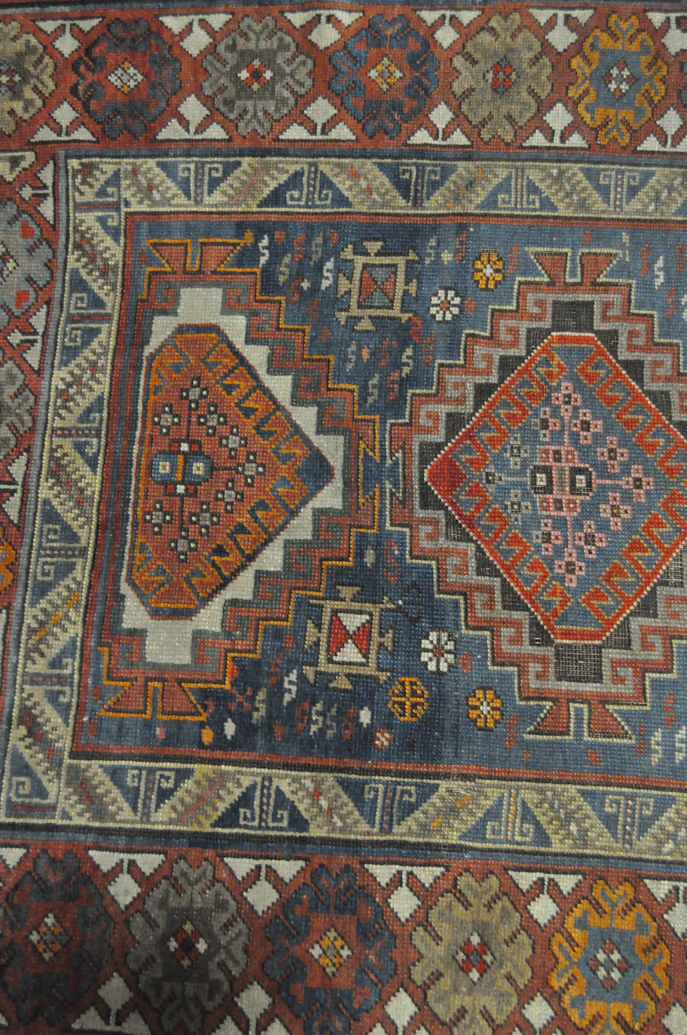 A 20th century Kazak style wool rug, woven with geometric lozenges on a blue ground with red border, - Image 13 of 13