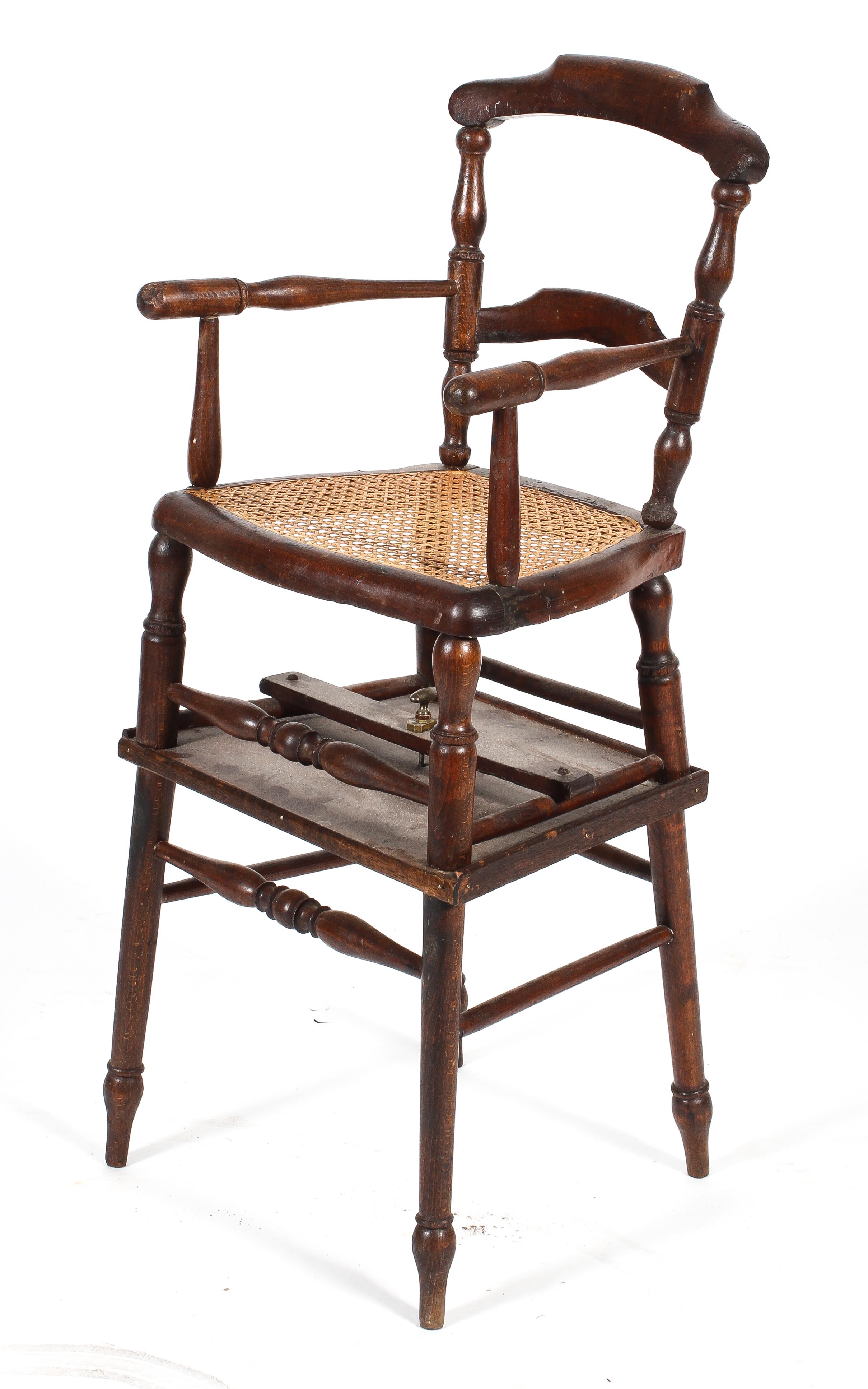 A child's highchair with turned arms and caned seat,