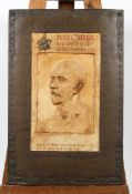 A commemorative plaster and copper plaque, cast with a stained plaster portrait of John Clough,