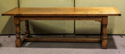 A large oak refectory table, on four large turned supports joined by plain stretchers,