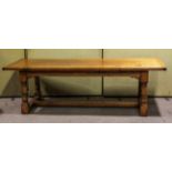 A large oak refectory table, on four large turned supports joined by plain stretchers,