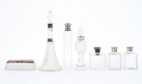 A collection of Victorian and Edwardian silver topped jars and scent bottles and stoppers,