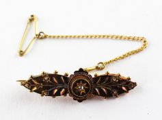 A yellow metal ornate bar brooch set with a rose cut diamond to centre. Stamped 15ct