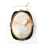 A large yellow metal cameo brooch having onyx and ruby surround,