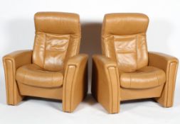 Two Fjords (Norwegian) reclining chairs, upholstered in pale tan leather style fabric,