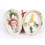 A bisque porcelain doll and four small painted wooden miniature figures,