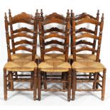 A set of six oak ladder back dining chairs with rush seats, with turned finials,
