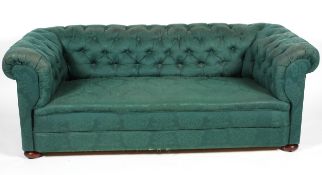 A Victorian button-back Chesterfield sofa, upholstered in dark green damask fabric, on bun feet,