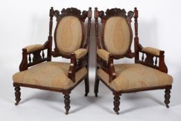 A pair of late Victorian armchairs, with upholstered back, arm rests and seat,