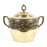 A brass two handled bowl and cover, possibly WMF, embossed with berries and flowers to the rim,