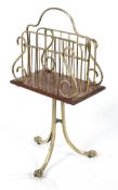 A brass and mahogany revolving magazine rack, on a tripod base,