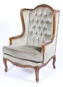 A Louis XV style armchair, the rocaille frame carved with scrolls and flowers,