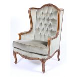 A Louis XV style armchair, the rocaille frame carved with scrolls and flowers,