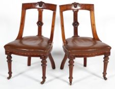 A pair of Victorian mahogany chairs, each carved with foliate medallion to top rail and splat,