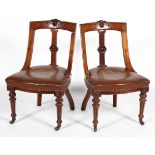 A pair of Victorian mahogany chairs, each carved with foliate medallion to top rail and splat,