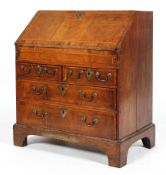 A George III walnut bureau, with cross banded top,