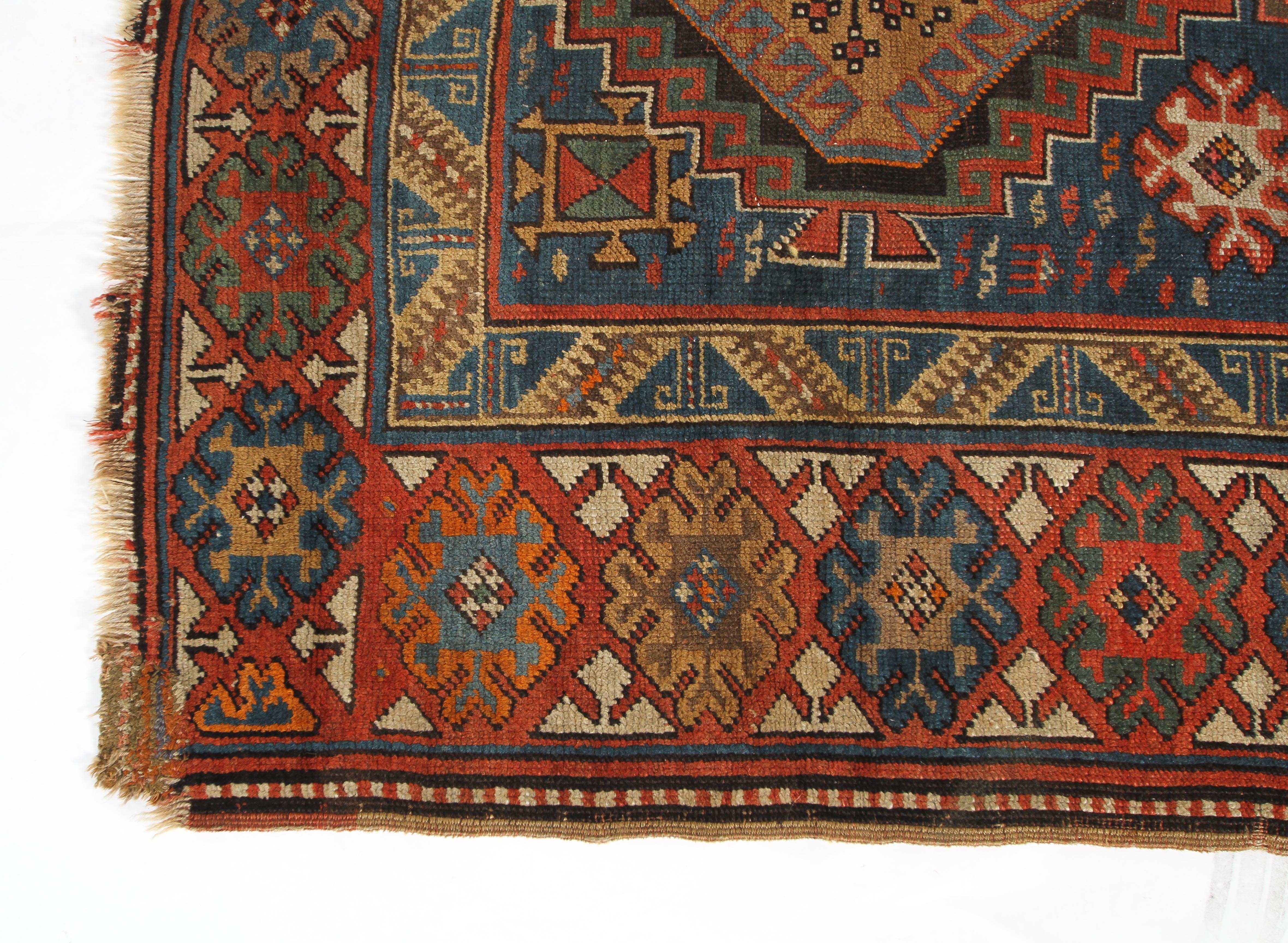 A 20th century Kazak style wool rug, woven with geometric lozenges on a blue ground with red border, - Image 2 of 13