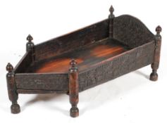 An Indian carved hardwood cot, of pointed rectangular form,
