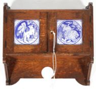 A Victorian oak Gothic Revival hanging wall cupboard mounted with two Minton Aesop's Fables tiles
