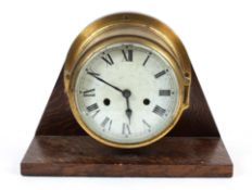 A brass ship's bulkhead clock on oak mount, early 20th century,