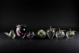 A collection of glass paperweights, including four with bubble inclusions, two formed as fruit,