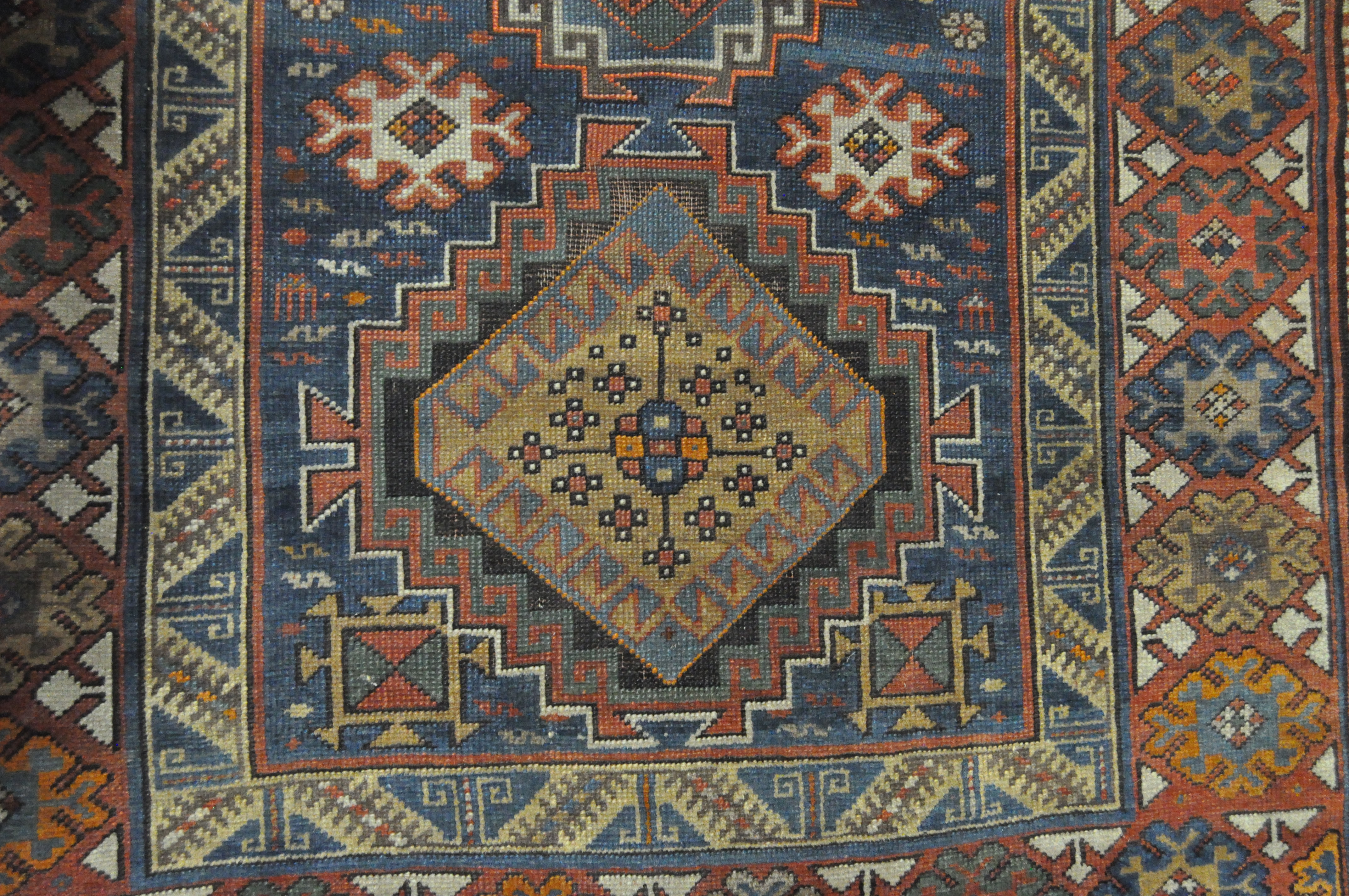 A 20th century Kazak style wool rug, woven with geometric lozenges on a blue ground with red border, - Image 11 of 13