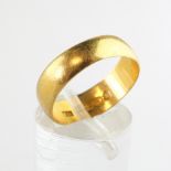 A yellow metal 6mm D shape wedding ring. Hallmarked 22ct gold, Birmingham. Size: O