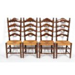 A set of four oak and rush ladder back dining chairs, each with turned uprights and stretchers,