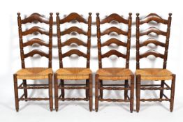 A set of four oak and rush ladder back dining chairs, each with turned uprights and stretchers,