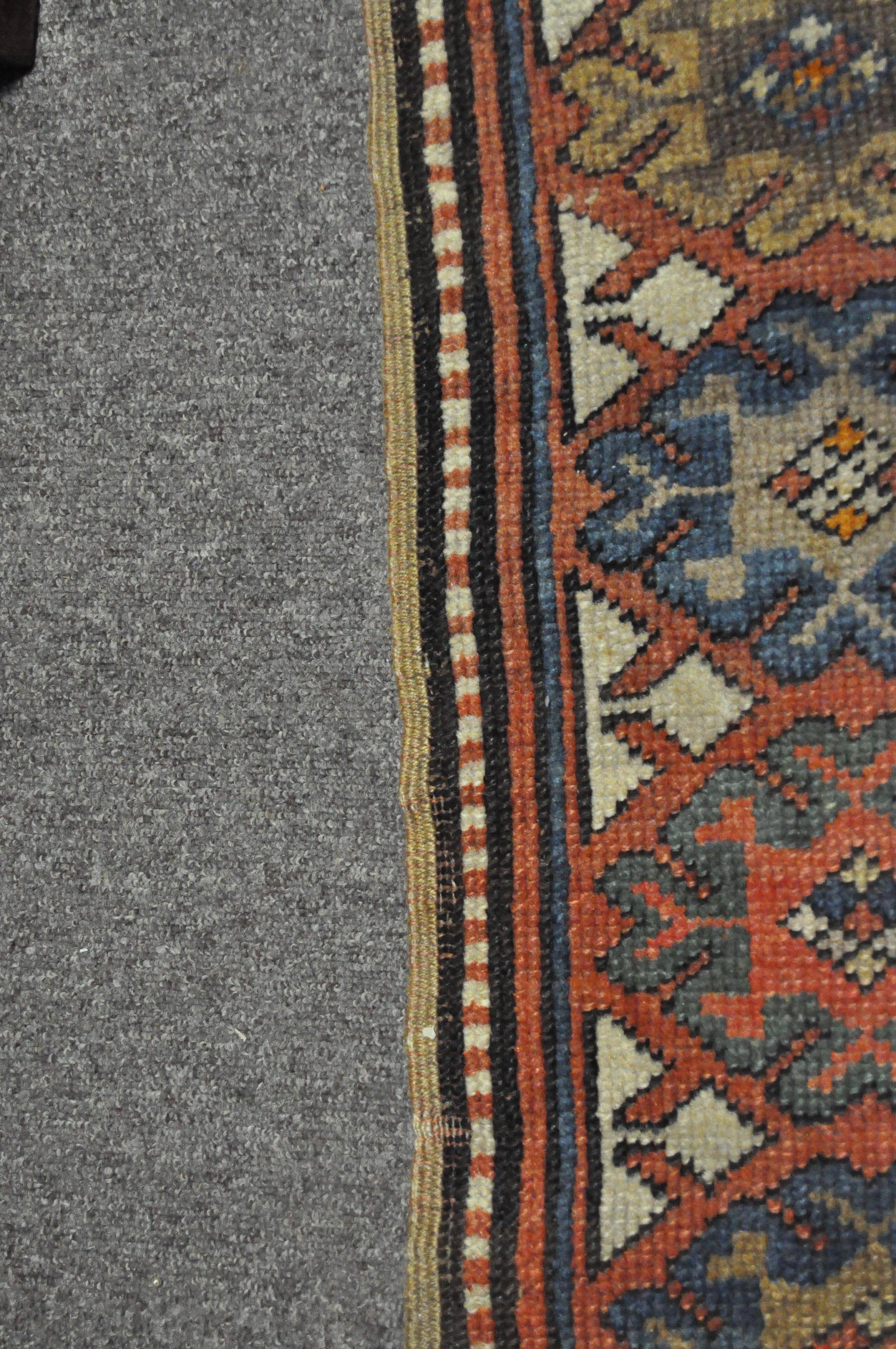 A 20th century Kazak style wool rug, woven with geometric lozenges on a blue ground with red border, - Image 10 of 13