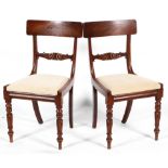 A pair of Regency style mahogany dining chairs with bar backs, drop in seats and turned front legs,