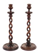 A pair of barley twist mahogany candlesticks, with baluster turned sconces,