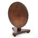 A mahogany miniature or apprentice tilt top table on a tripod base and bun feet,